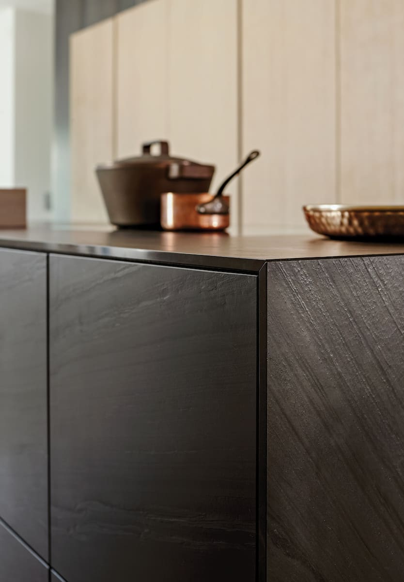 closeup of kitchen island front clad with phyllite black quartz from eggersmann unique cabinetry collection