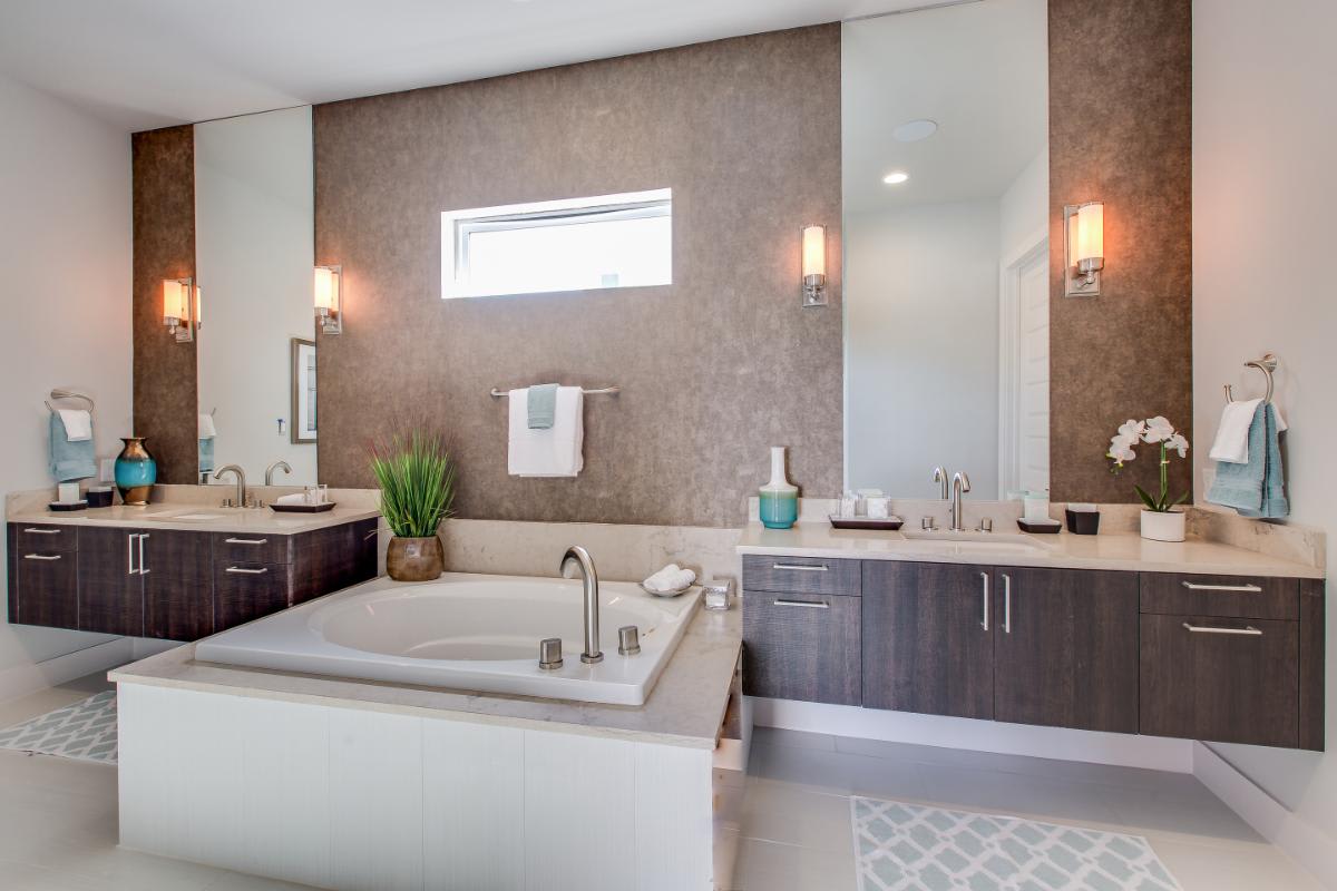 eggersmann-designed luxury bath featuring a garden bath tub in between twin vanities in a dark wood veneer finish in a residence of royal oaks courtyard villas in houston