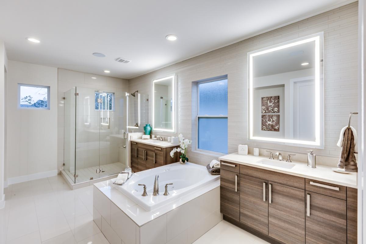 eggersmann-designed bath featuring wood veneer cabinetry fronts and a garden bath tub and glass shower in a residence in royal oaks courtyard villas in houston