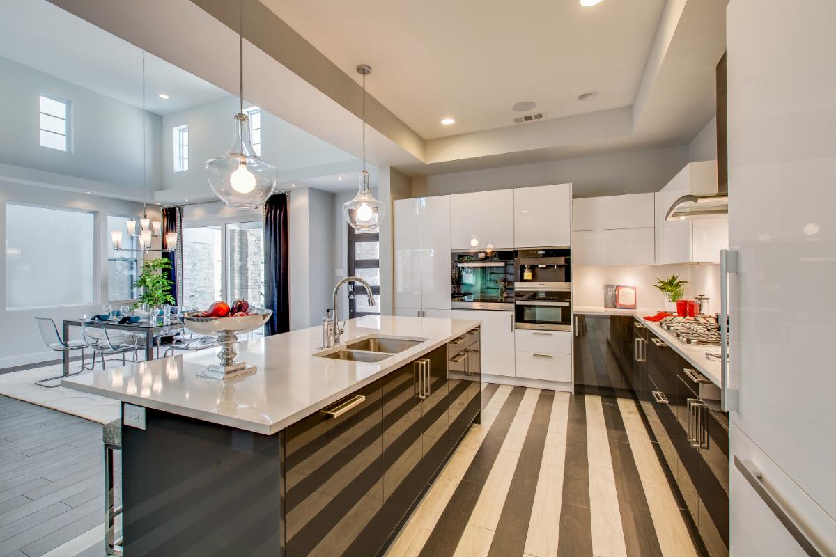 striped floors in a gloss white and dark lacquered cabinetry in a kitchen designed by eggersmann for a garden townhome in royal oaks courtyard villas in houston