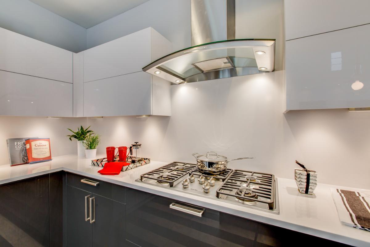 gloss white and dark lacquered cabinetry in a kitchen designed by eggersmann for a garden townhome in royal oaks courtyard villas in houston