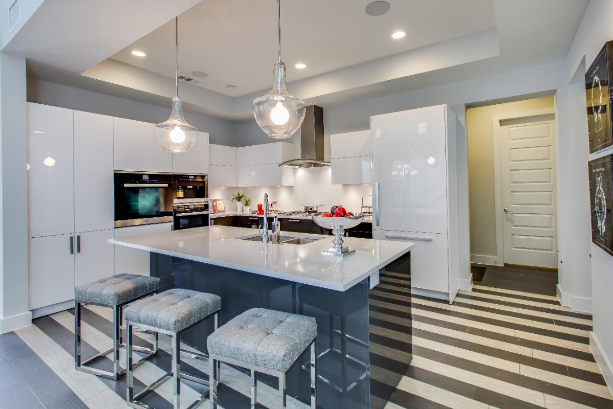 striped floors in a gloss white and dark lacquered cabinetry with dark kitchen island in a kitchen designed by eggersmann for a garden townhome in royal oaks courtyard villas in houston