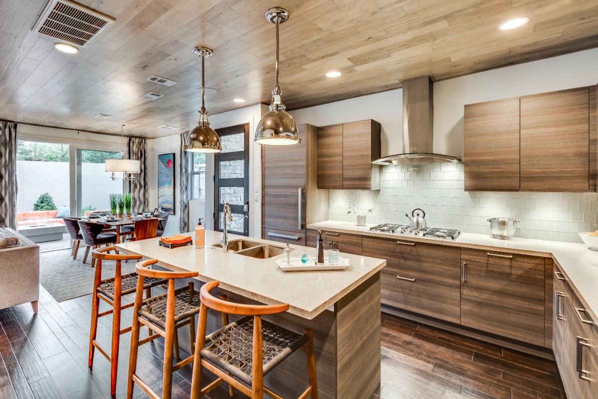 living area and kitchen designed by eggersmann with warm wood veneer cabinetry in a garden townhome in royal oaks courtyard villas in houston