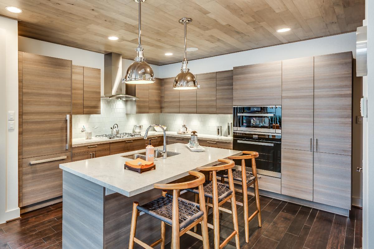 kitchen designed by eggersmann with warm wood veneer cabinetry in a garden townhome in royal oaks courtyard villas in houston