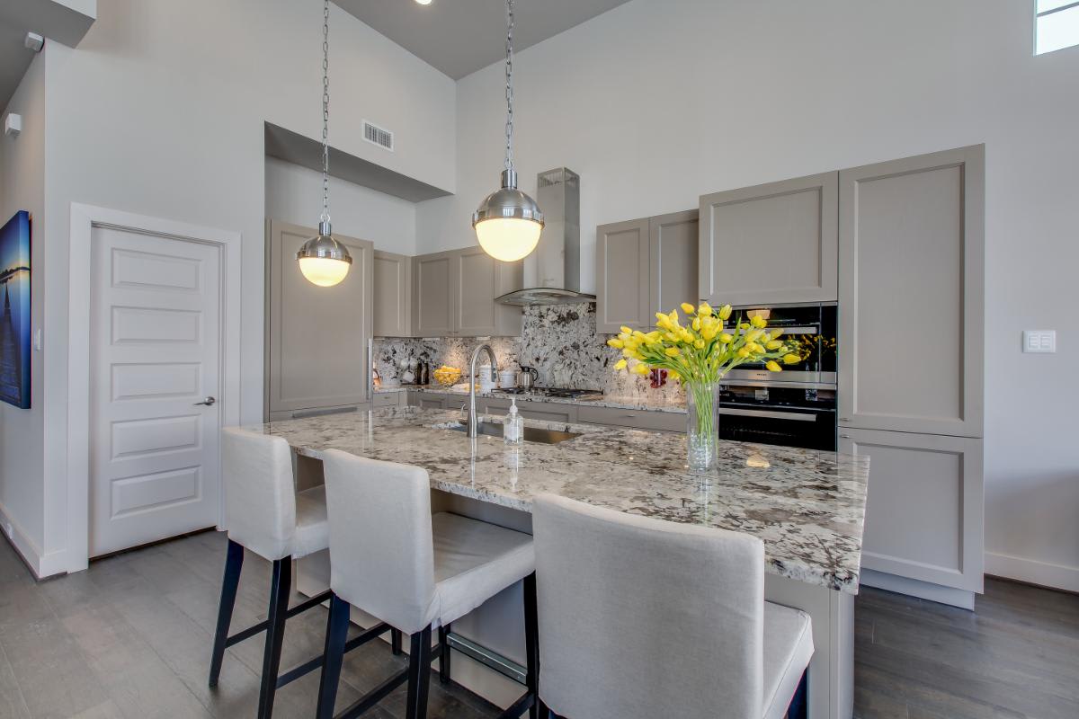 luxury kitchen designed by eggersmann with light taupe decor laminate cabinetry and island in a home in royal oaks courtyard villas in houston
