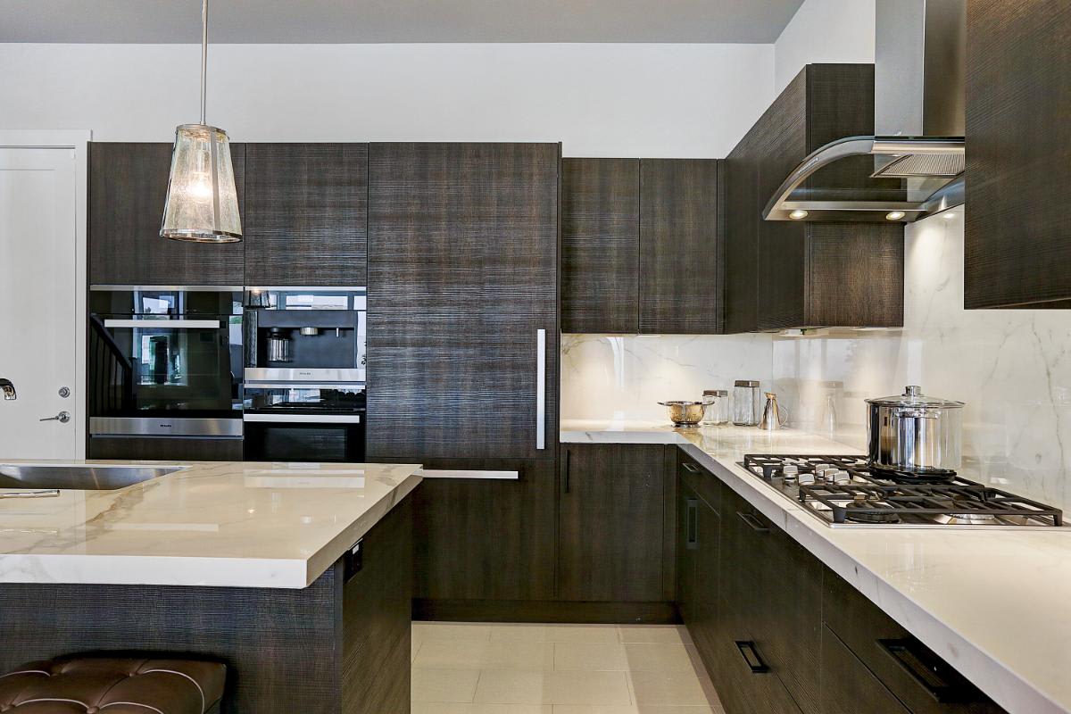 eggersmann-designed kitchen featuring cabinetry in a grain-matched dark wood veneer in a home in royal oaks courtyard villas in houston