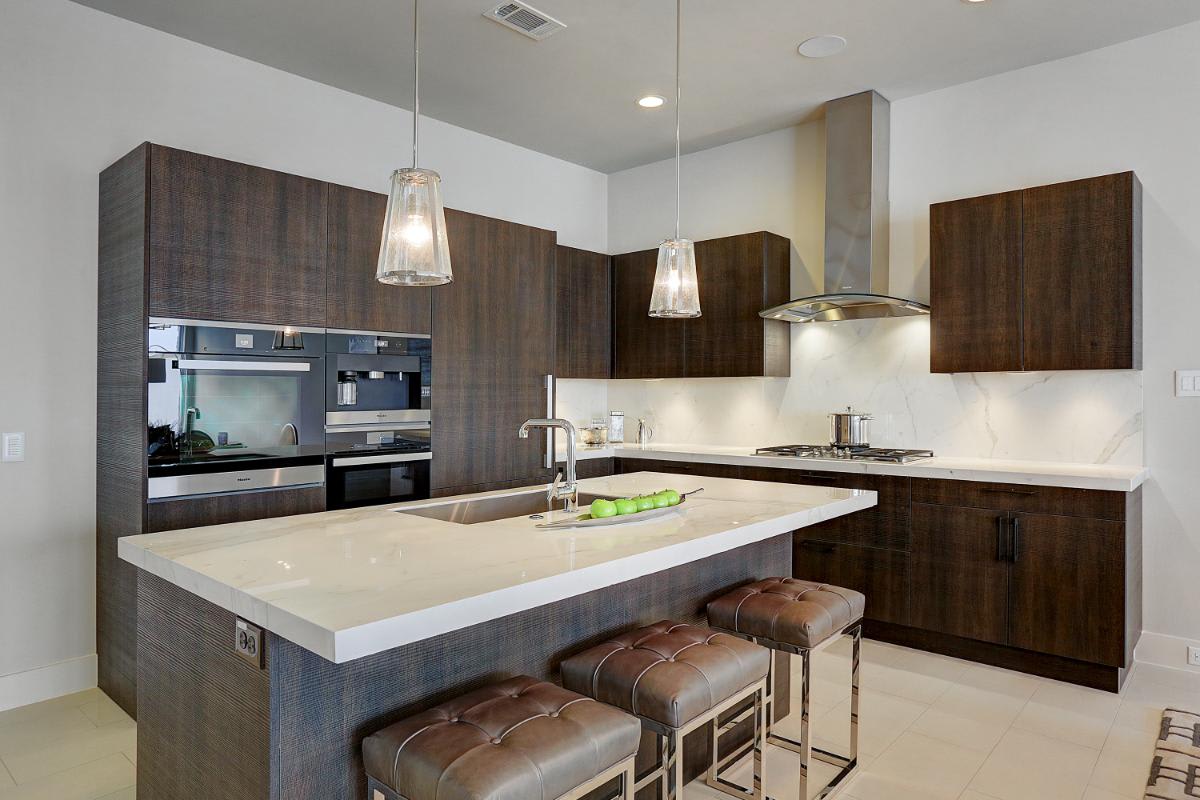 side view of an eggersmann-designed kitchen featuring cabinetry in a grain-matched dark wood veneer in a home in royal oaks courtyard villas in houston