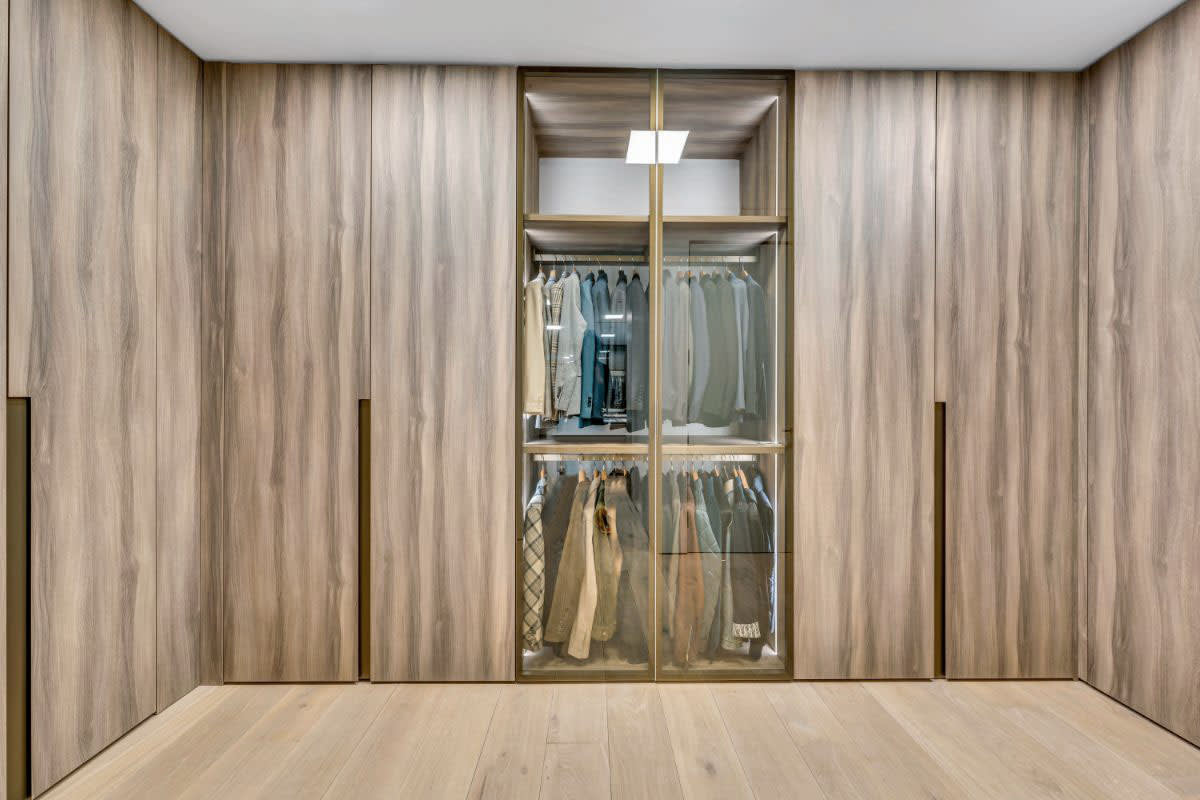 glass-encased and hidden hanging and shelving in a master closet in 8899 beverly blvd