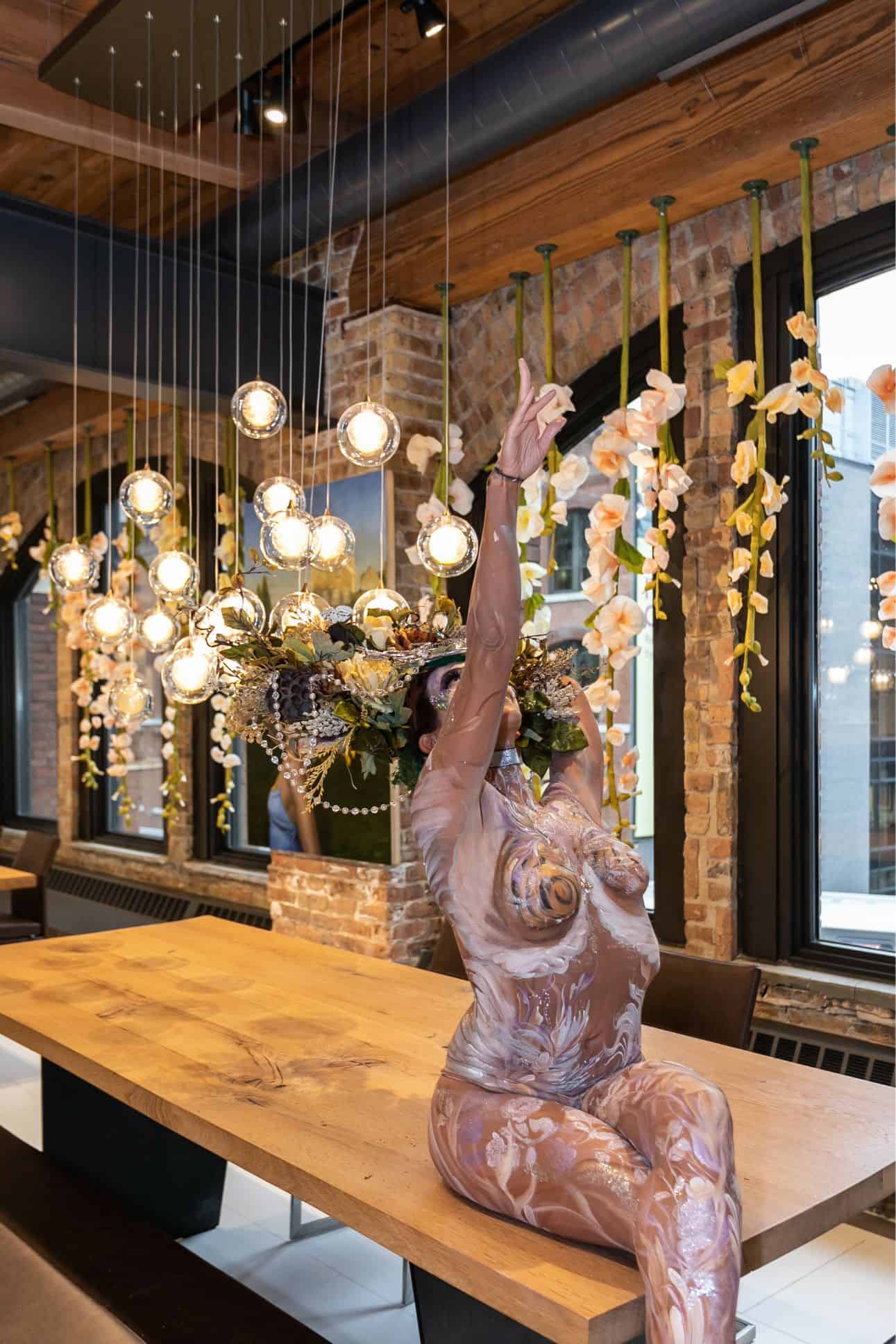 the living statue sitting atop an eggersmann dining table at the rndd gallery walk 2019 inside the eggersmann chicago showroom