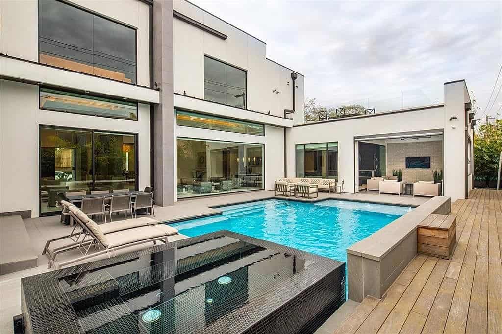 tanglewood homes' expansive backyard deck with pool and outdoor kitchen and lounge