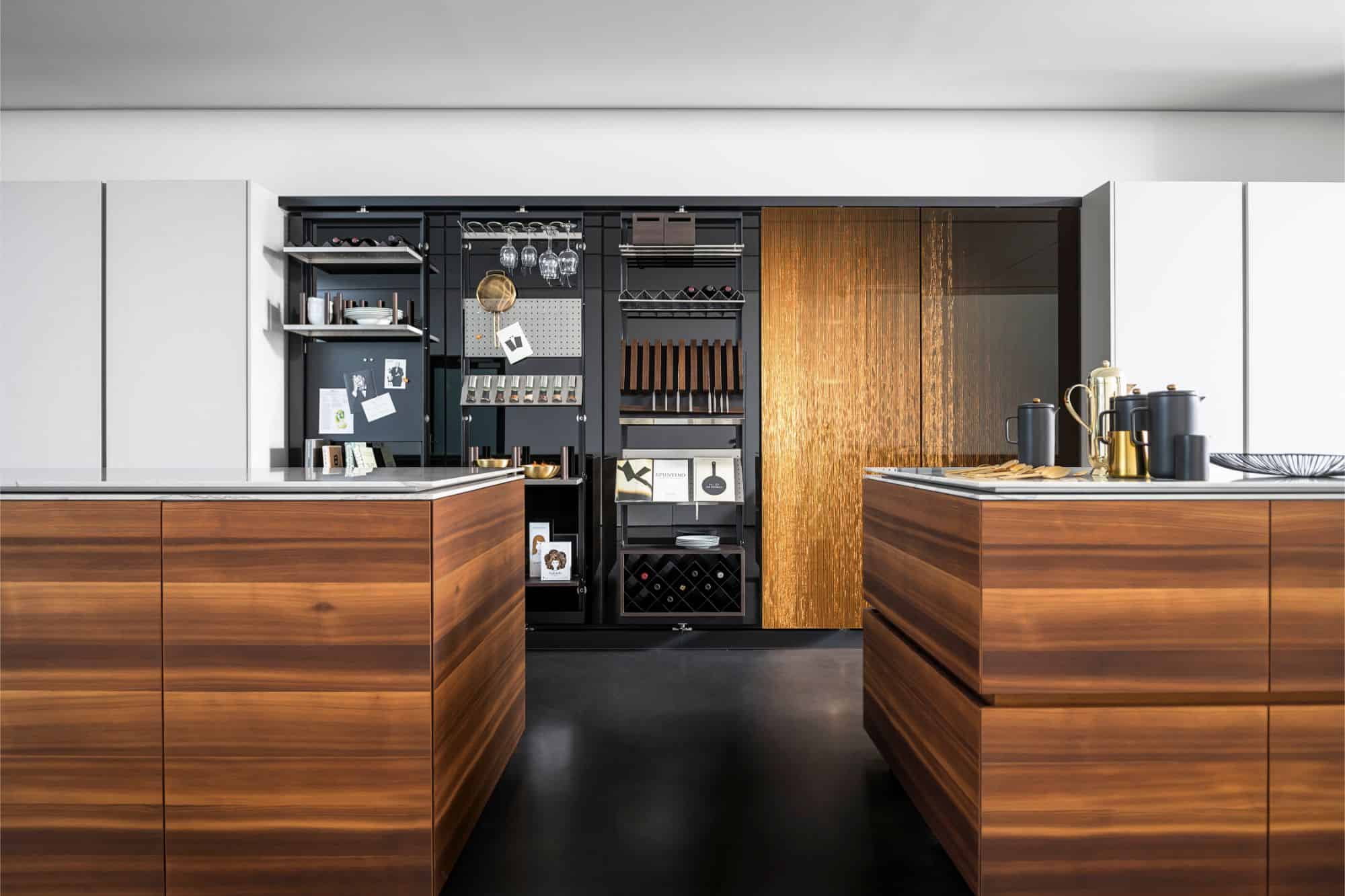 eggers2020 innovations include this kitchen's features such as smoked larch wood veneer, moving worktops from the motion collection, and interlink bronze finish cabinet fronts