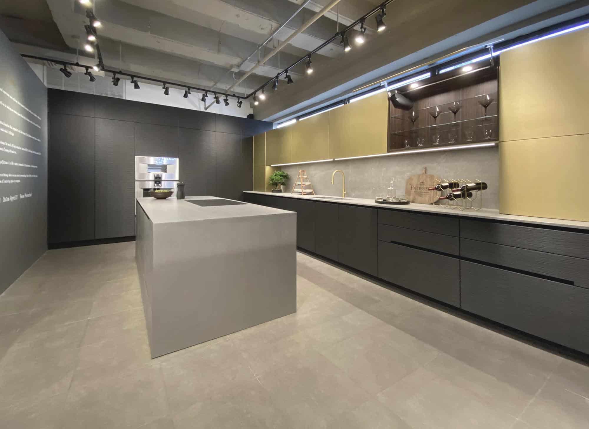 brass and stainless steel finishes with dark textured wood make a bold statement in a contemporary kitchen with an upper cabinet open to show storage space