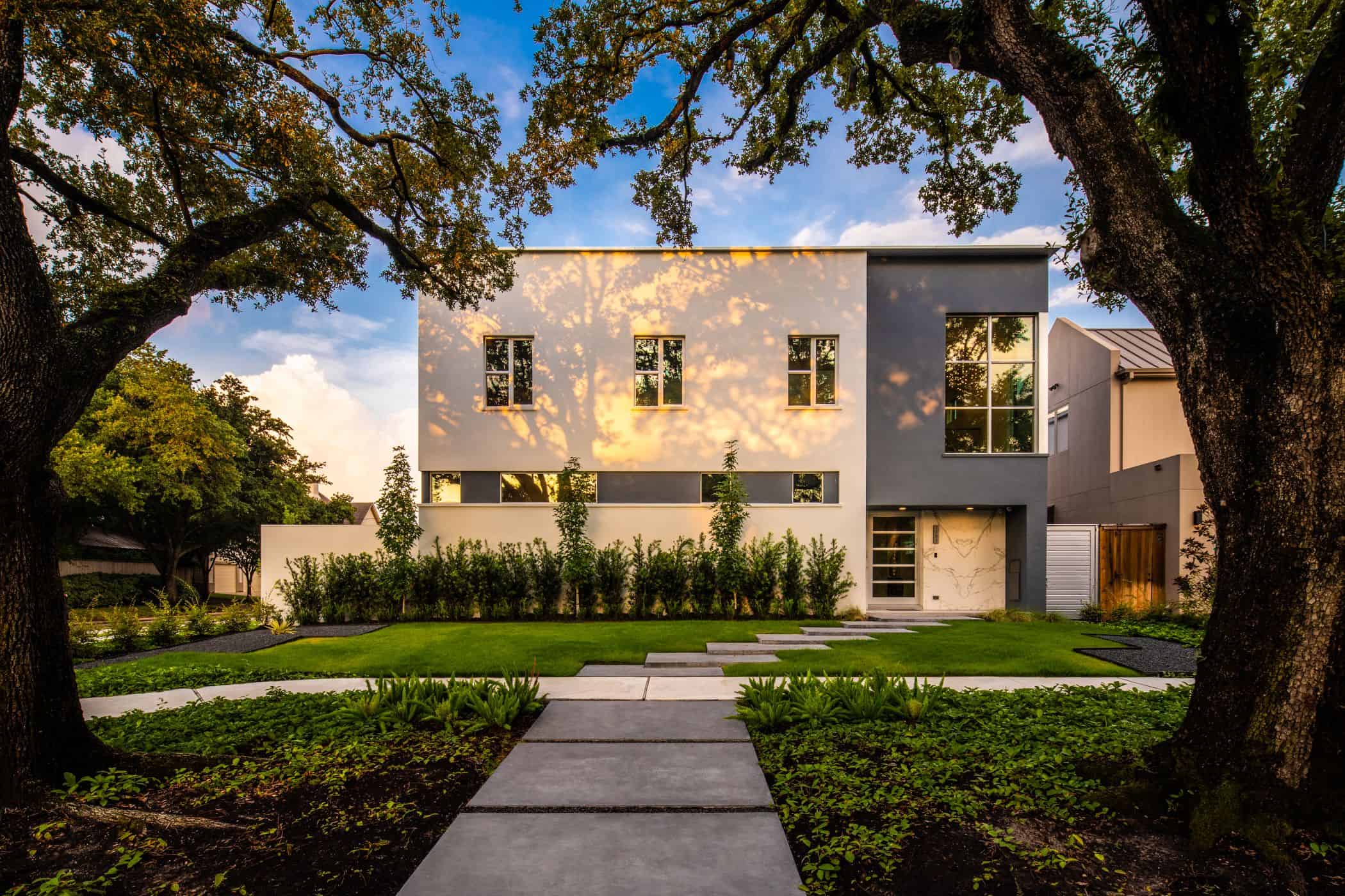 new construction home in upper kirby area of houston features ultra modern architecture framed by beautiful century old oak trees