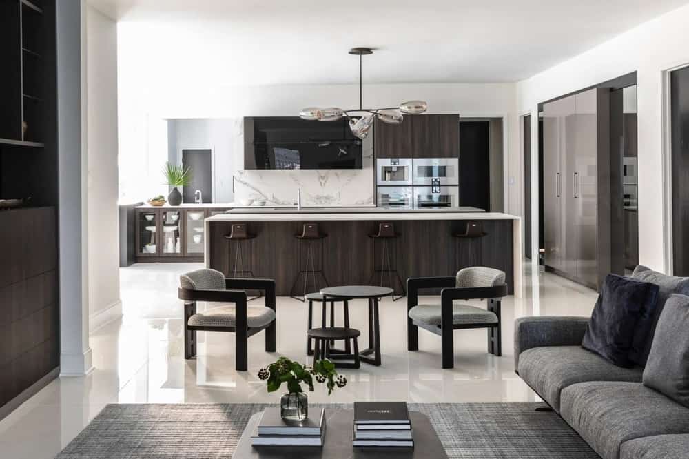luxury kitchen and living room with light streaming in from ample windows