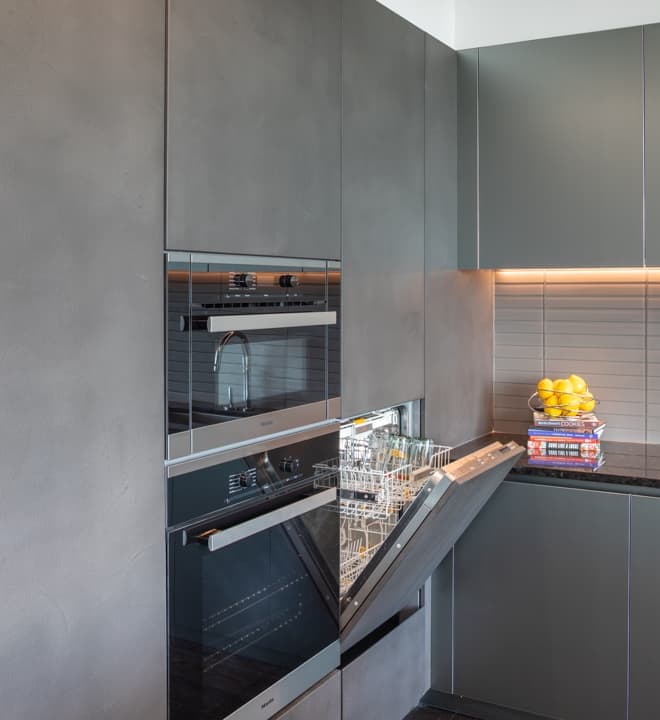 built-in miele dishwasher is fully integrated into the custom cabinetry in unit 601 kitchen at the mond luxury condos