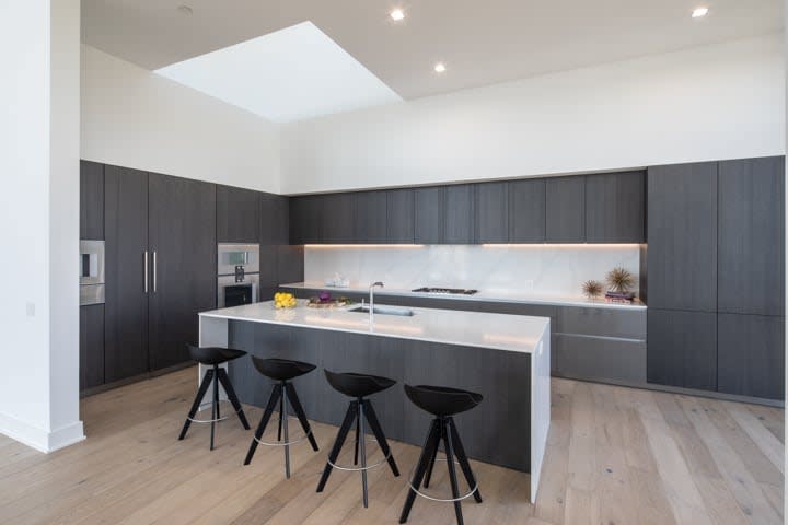 smoked and fumed alder with white cascade countertop island in the penthouse condo unit 801 of the mond at the museums