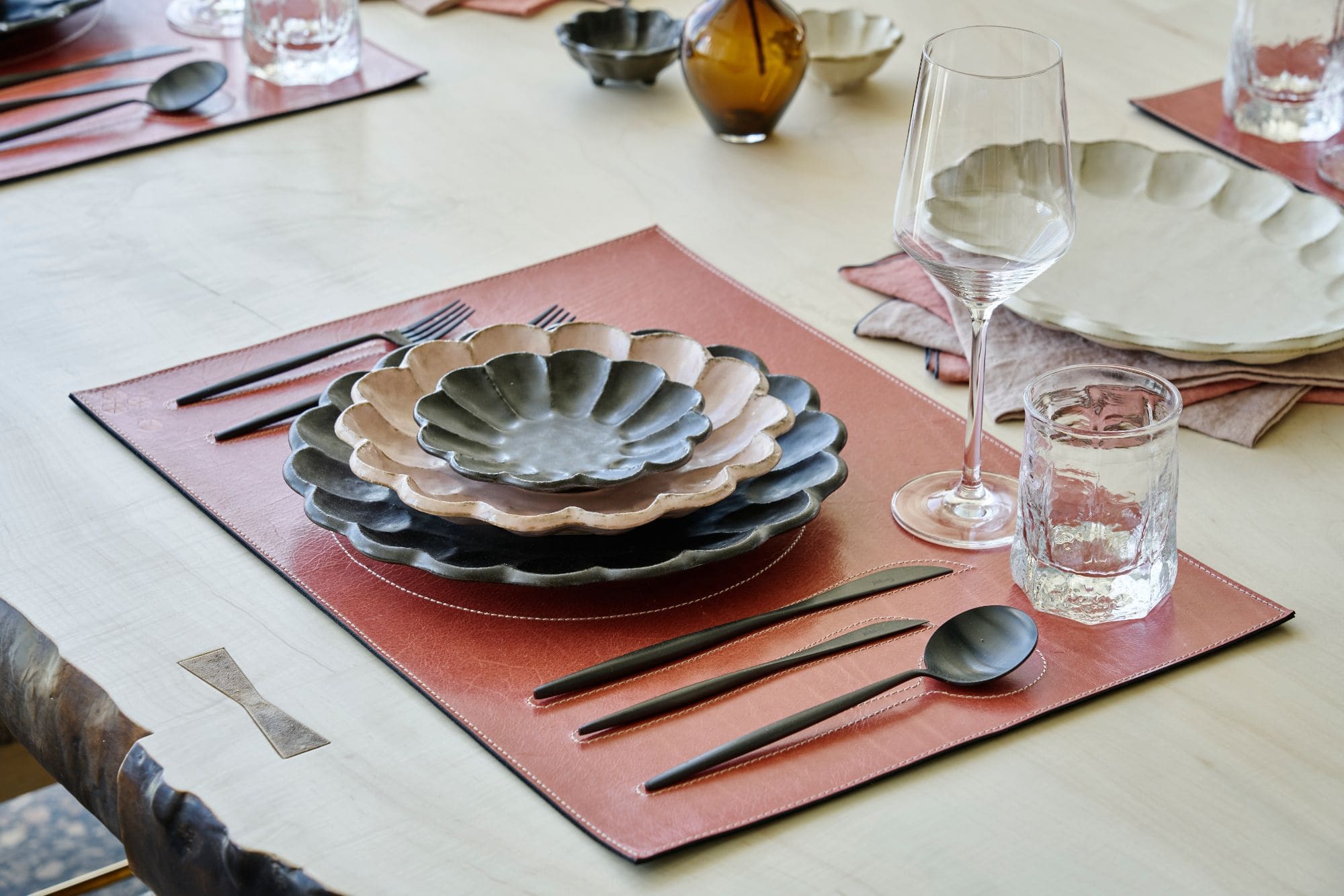 unique dinner setting featuring a series of nesting flower-shaped plates and saucers inside a penthouse of the arabella luxury high rise in houston