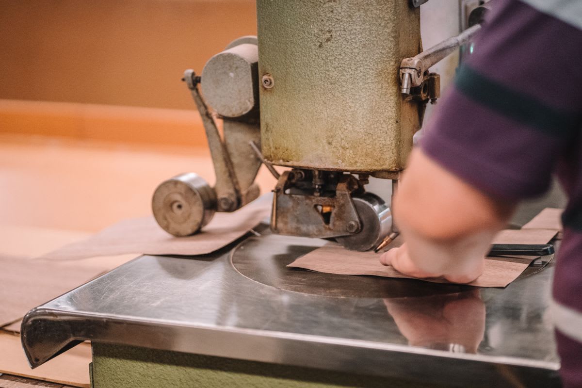 eggersmann craftsmann uses a seam press while factory hand stitching matched wood veneers