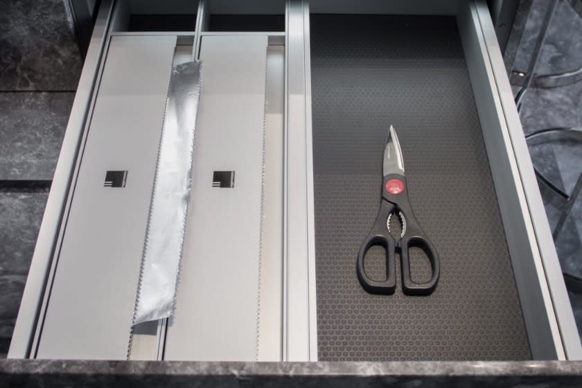 foil and plastic wrap organizers with scissors eggersmann dinnerware organizer in german cabinetry in a kitchen at the huntingdon luxury high-rise on kirby in houston