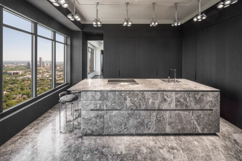 straight-on view of island and hidden wall cabinet storage in a luxury kitchen in the huntingdon luxury high-rise on kirby in houston