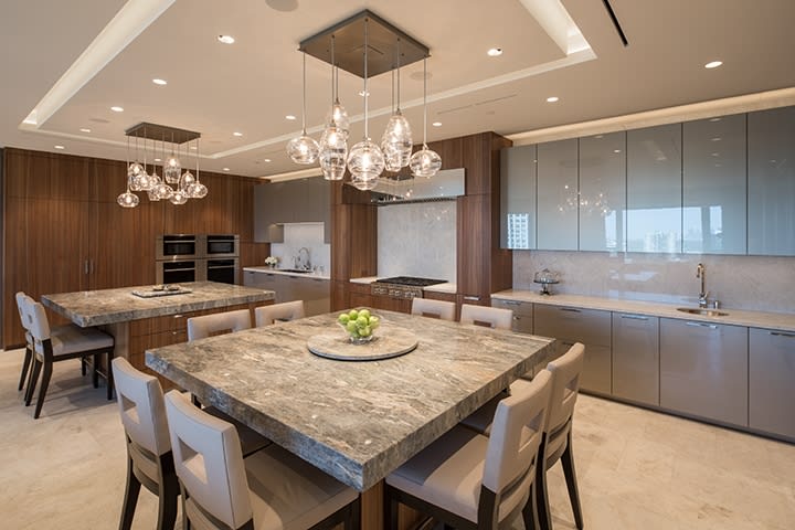 custom double-island kitchen featuring wood, stone, and sleek glass finishes custom double-island kitchen featuring wood, stone, and sleek glass finishes in an eggersmann kitchen in belfiore condos in houston