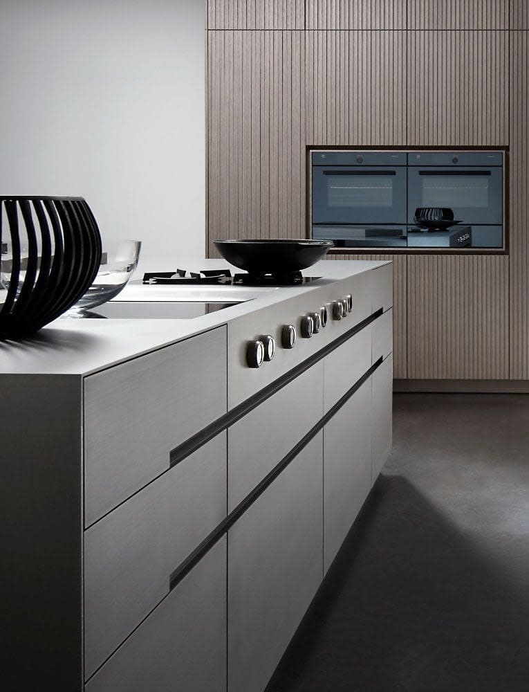 kitchen island in decor melamine of an eggersmann-designed kitchen featuring wall cabinetry with lausanne tambour style wood veneer finish