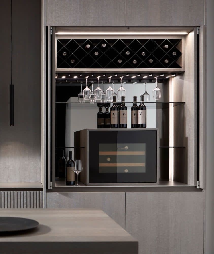 wine bar hidden behind pocket doors in an eggersmann-designed kitchen featuring lausanne tambour style wood veneer finish