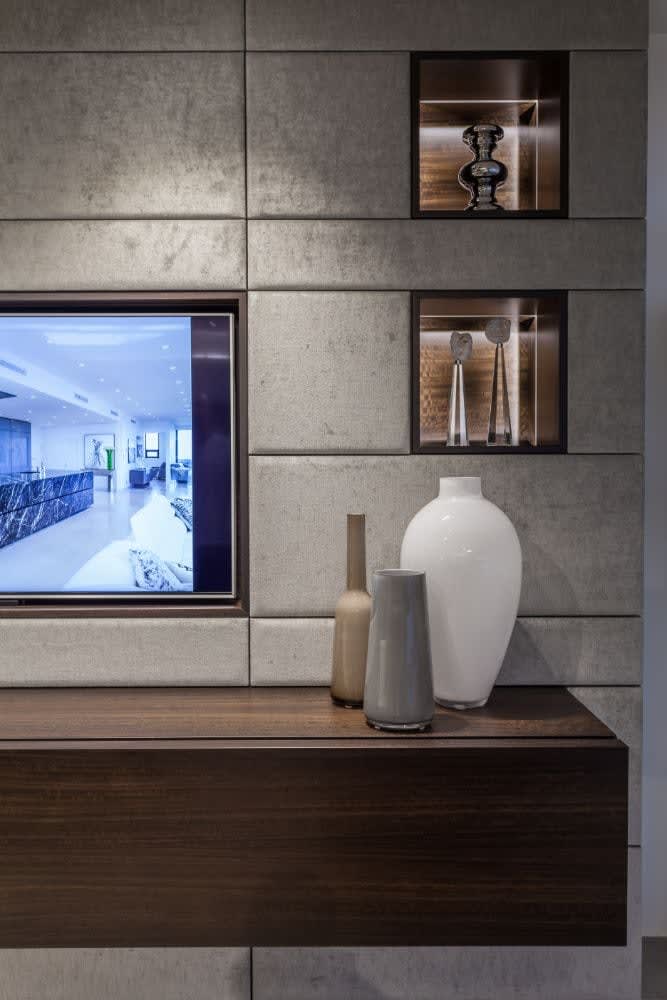 led lighting accents niches in an upholstered media wall designed by eggersmann