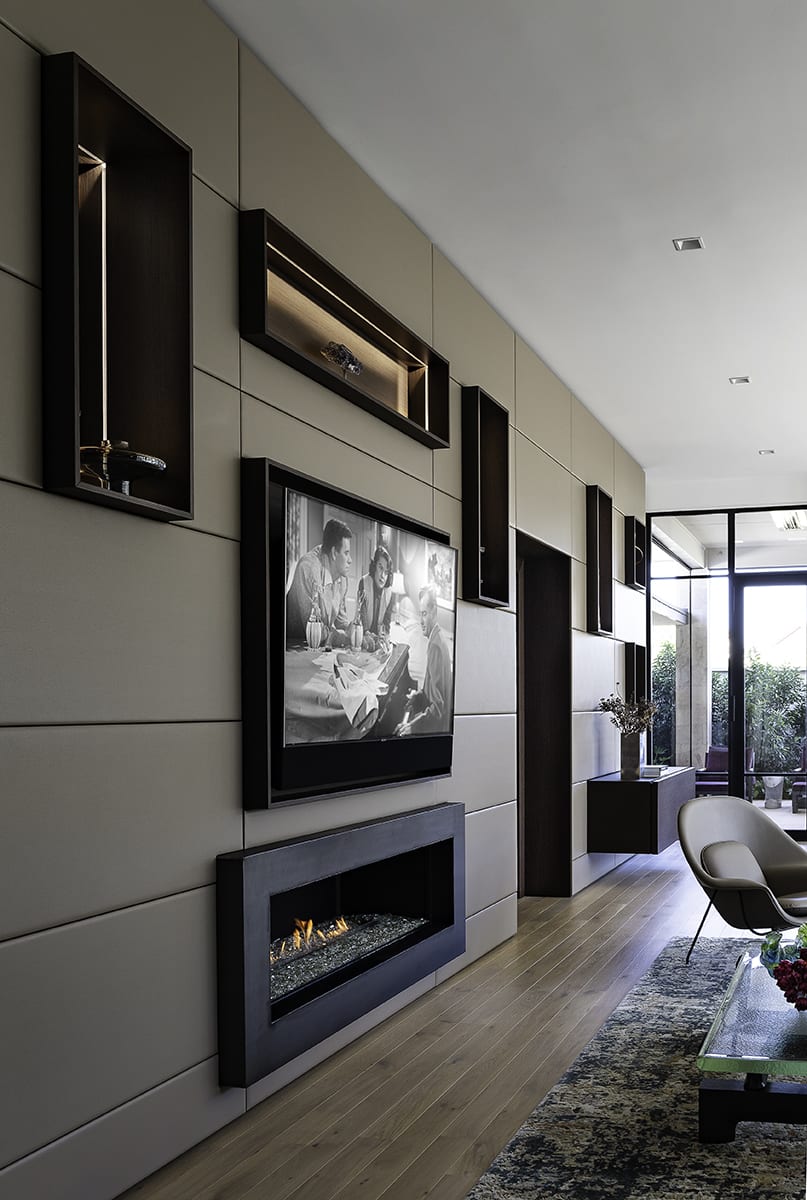 fireplace, tv, niches, and hidden storage in a modular highly functional modern wall of a living area of a southwest contemporary kitchen designed by eggersmann dallas
