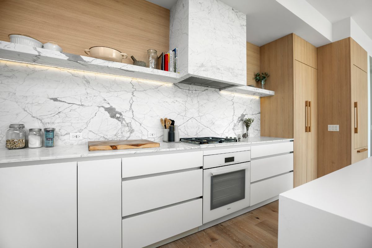 appliance wall with white melamine, marble, and light oak cabinetry in a luxury eggersmann kitchen in la's silver lake