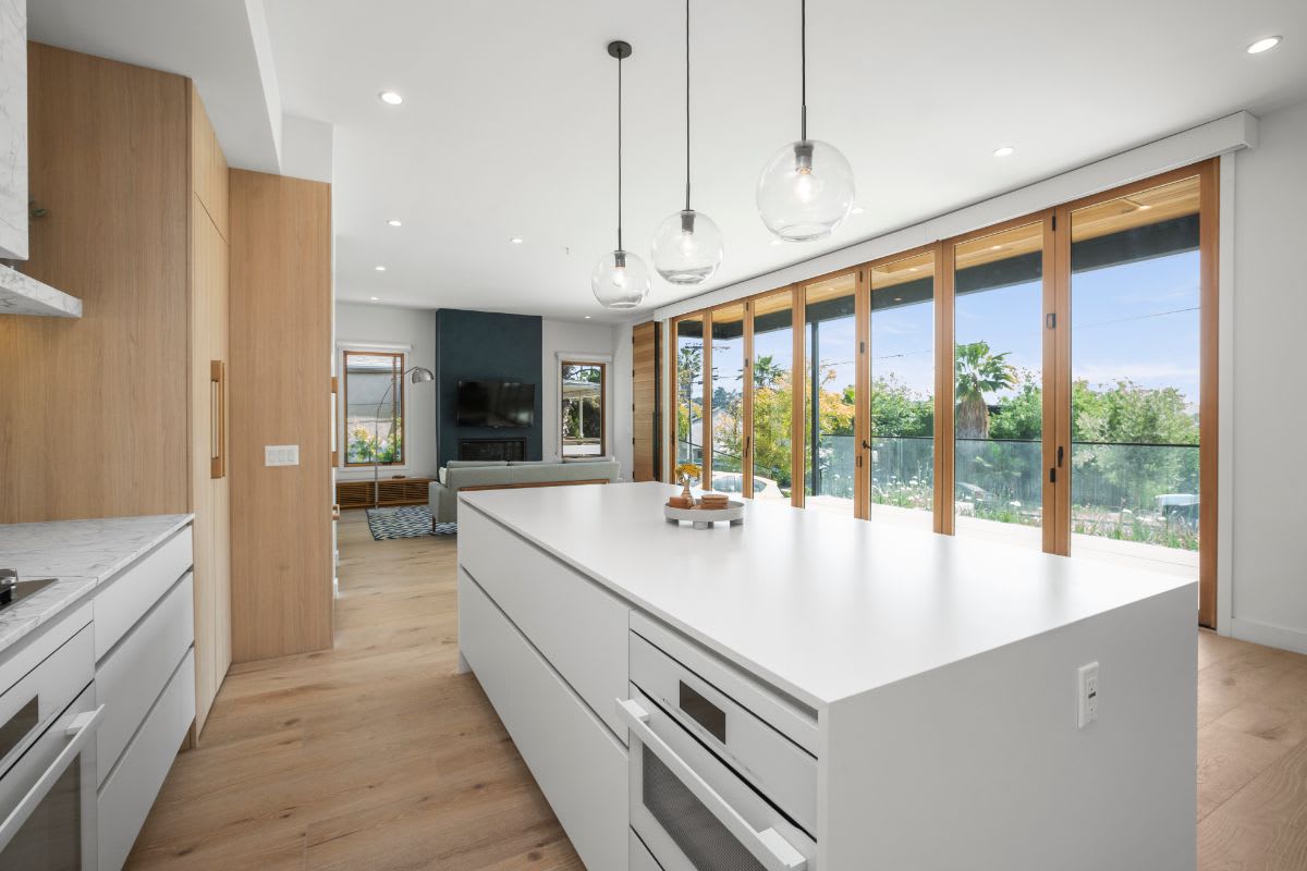 expansive bank of glass patio doors bring natural light into the airy luxury kitchen designed by eggersmann in la silver lake