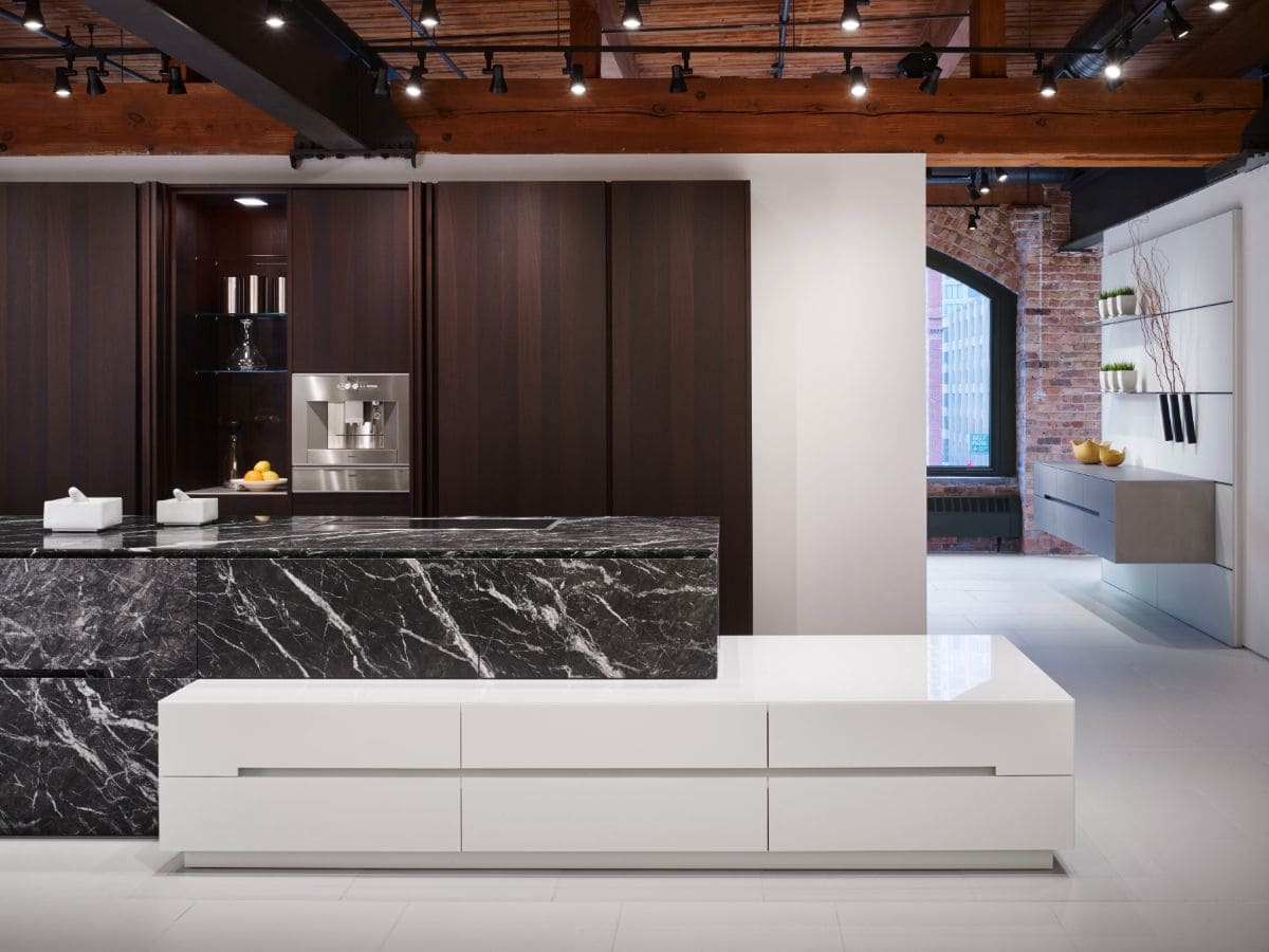 pocket doors on pantries of this luxury modern kitchen hide clutter
