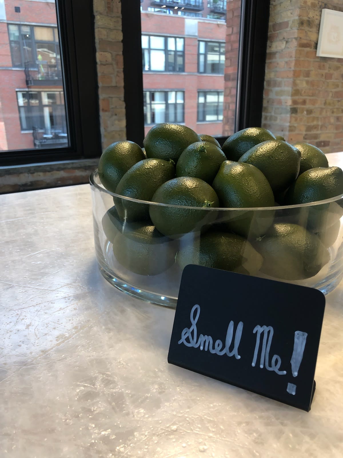 sign saying "smell me" inviting guests to smell the zest of a bowl of limes