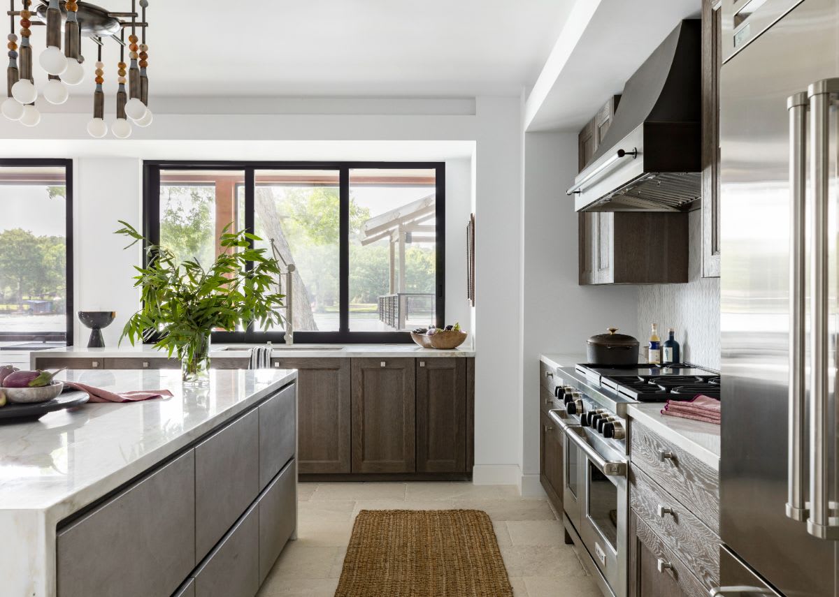 wolf range with custom hood and waterfall island in a luxury kitchen installed by eggersmann in austin