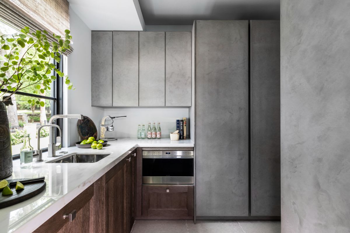 transitional luxury kitchen by eggersmann combining traditional framed doors with cabinet knobs juxtaposed to concrete veneer handle-less doors