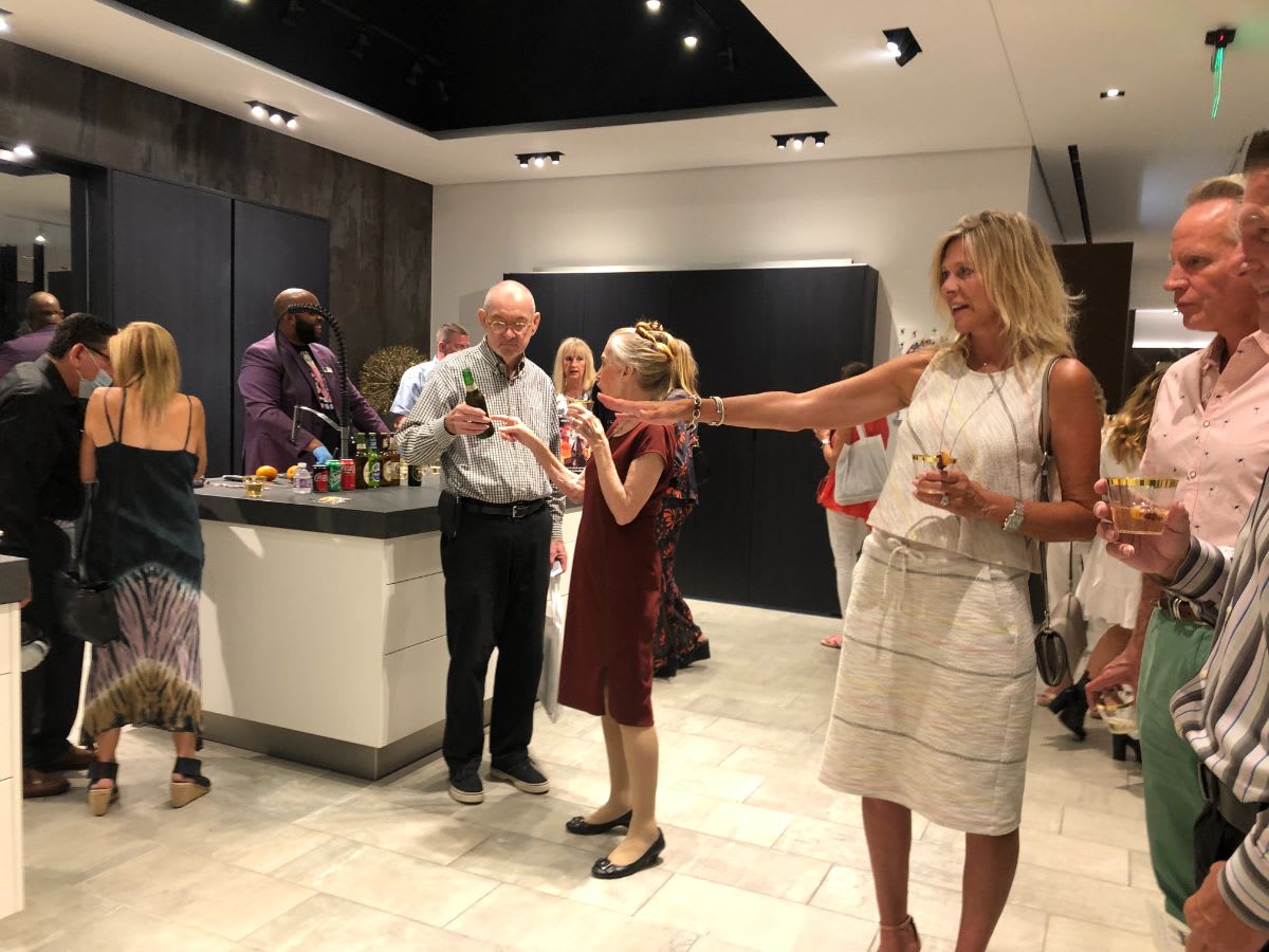 attendees enjoying the eggersmann dallas showroom during curated 2021 art exhibition and dallas design district showroom tour