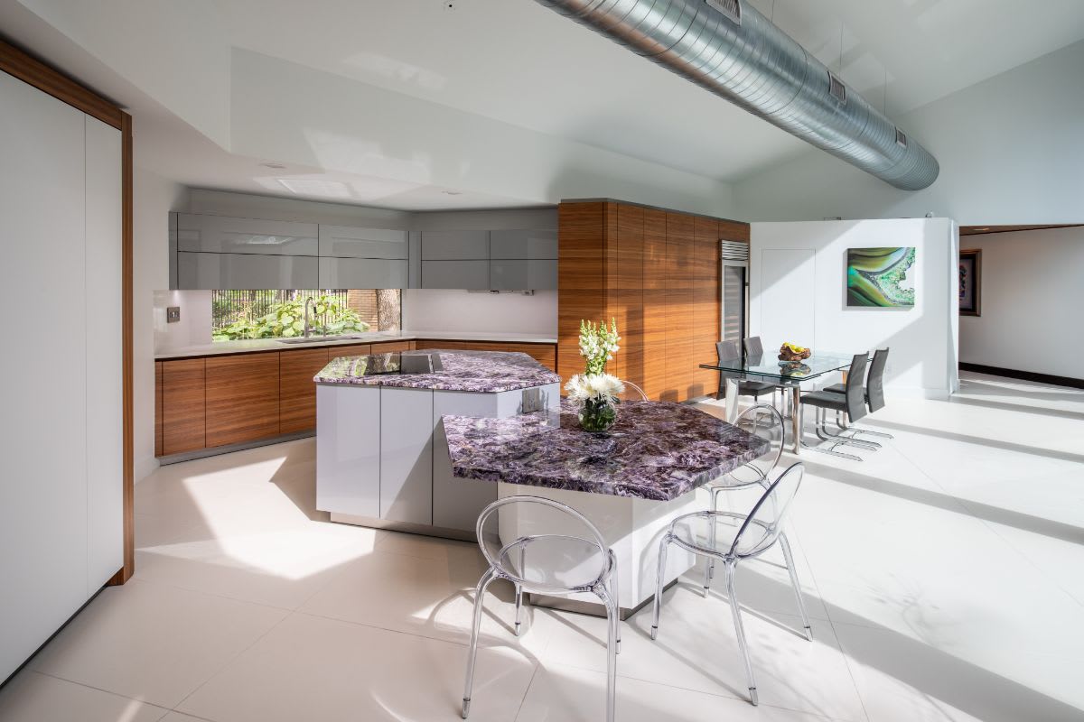 very peri kitchen and dining area designed by eggersmann with bright sunlight streaming in