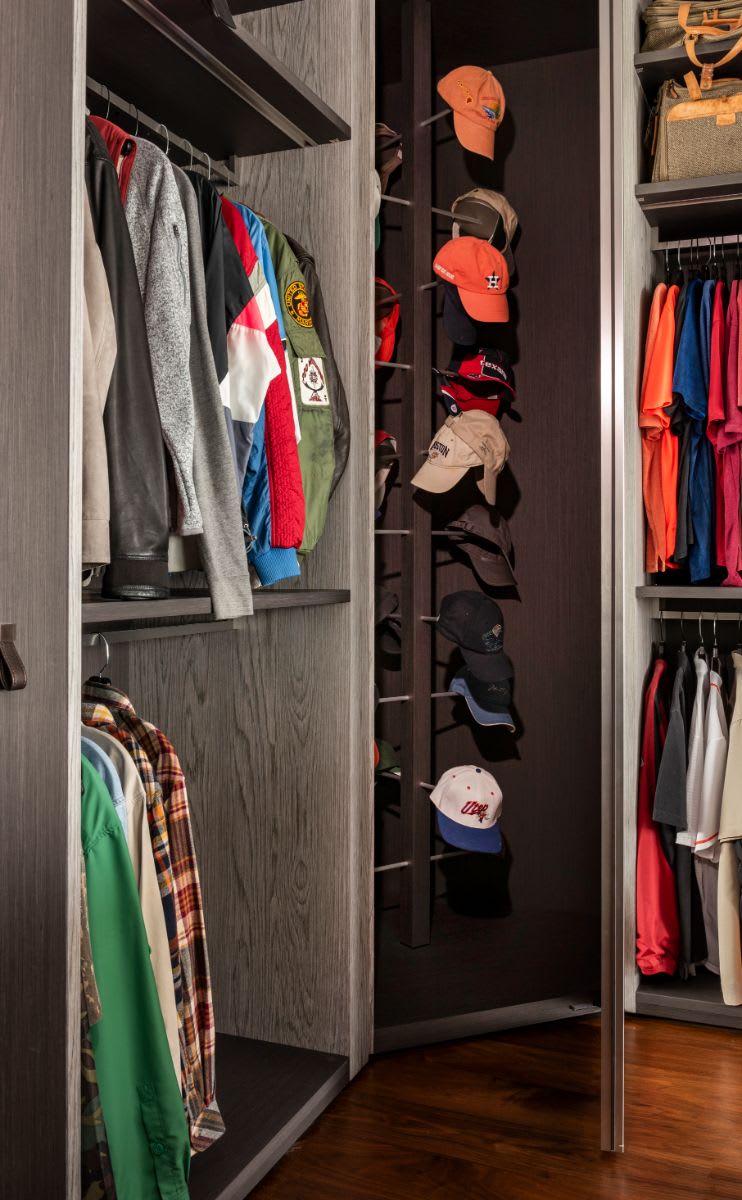 high-end closet with ample hanging space and a baseball cap organizer