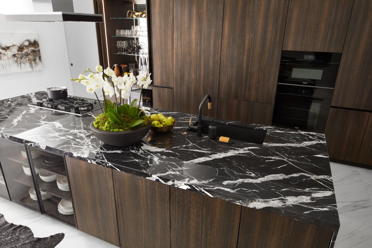 top view of a kitchen island from eggersmann's unique cabinetry collection clad in Nero Carrara Marble and Trondheim Acacia Dark wood veneer