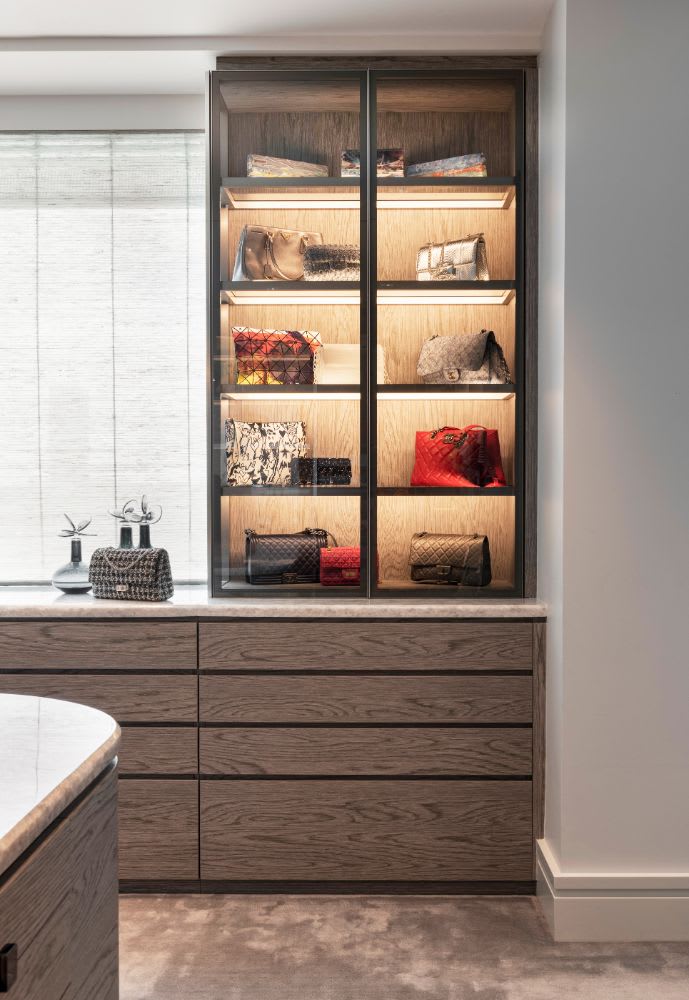in this belfiore houston penthouse, her closet features a glass-front cabinet for her purse collection