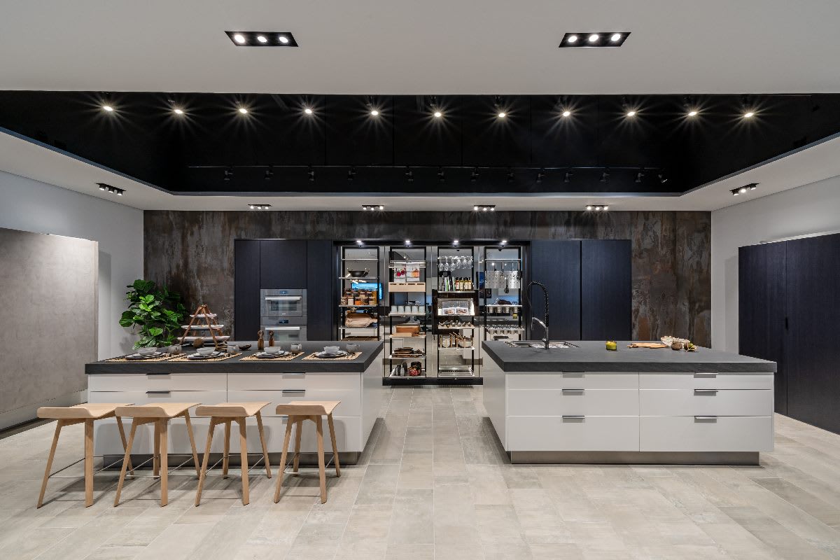 rotating pantries open in a black and white double island kitchen designed by eggersmann