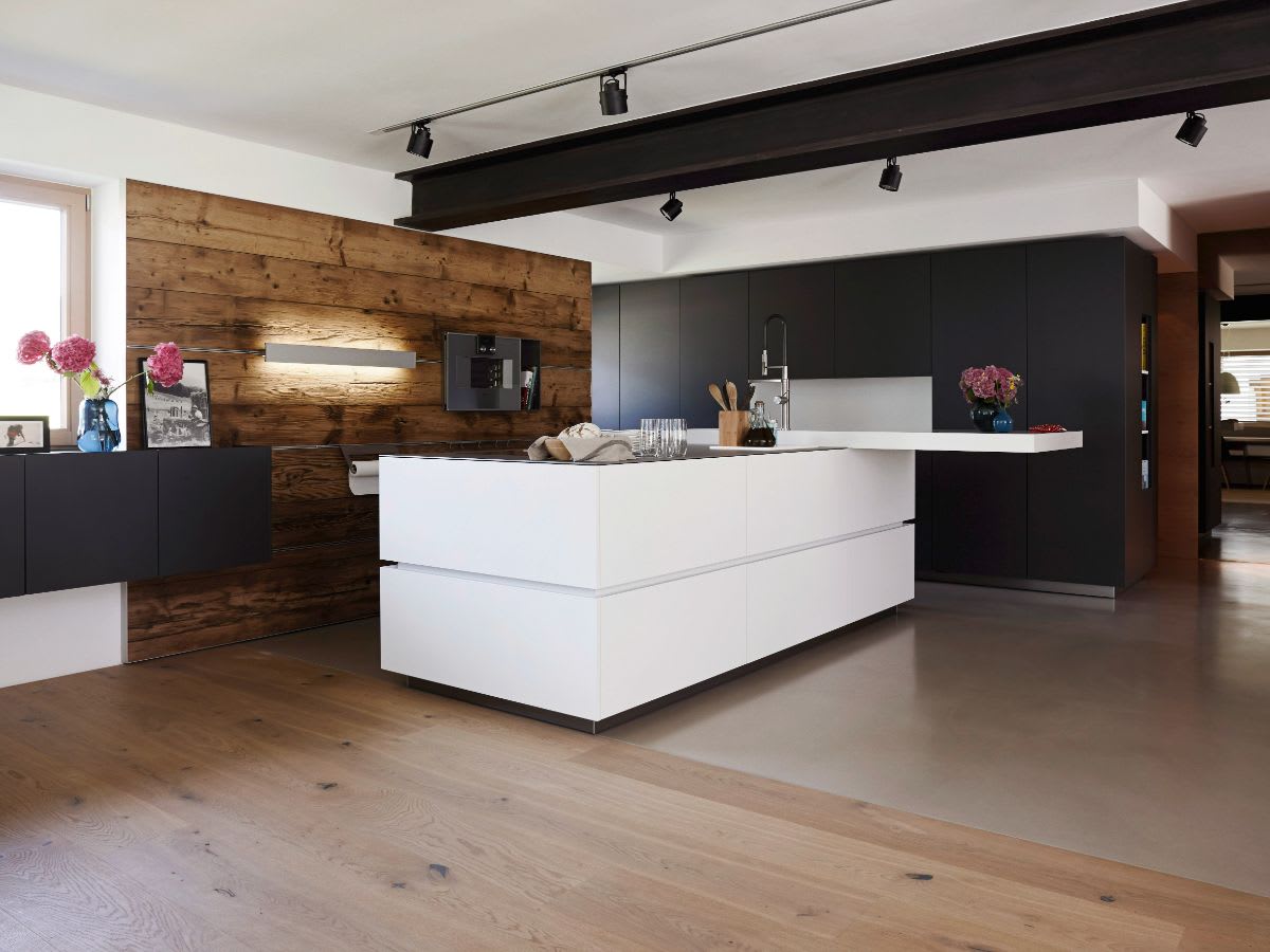 black and white kitchen with contrasting horizontal wood plank backsplash and black veneer ceiling beam