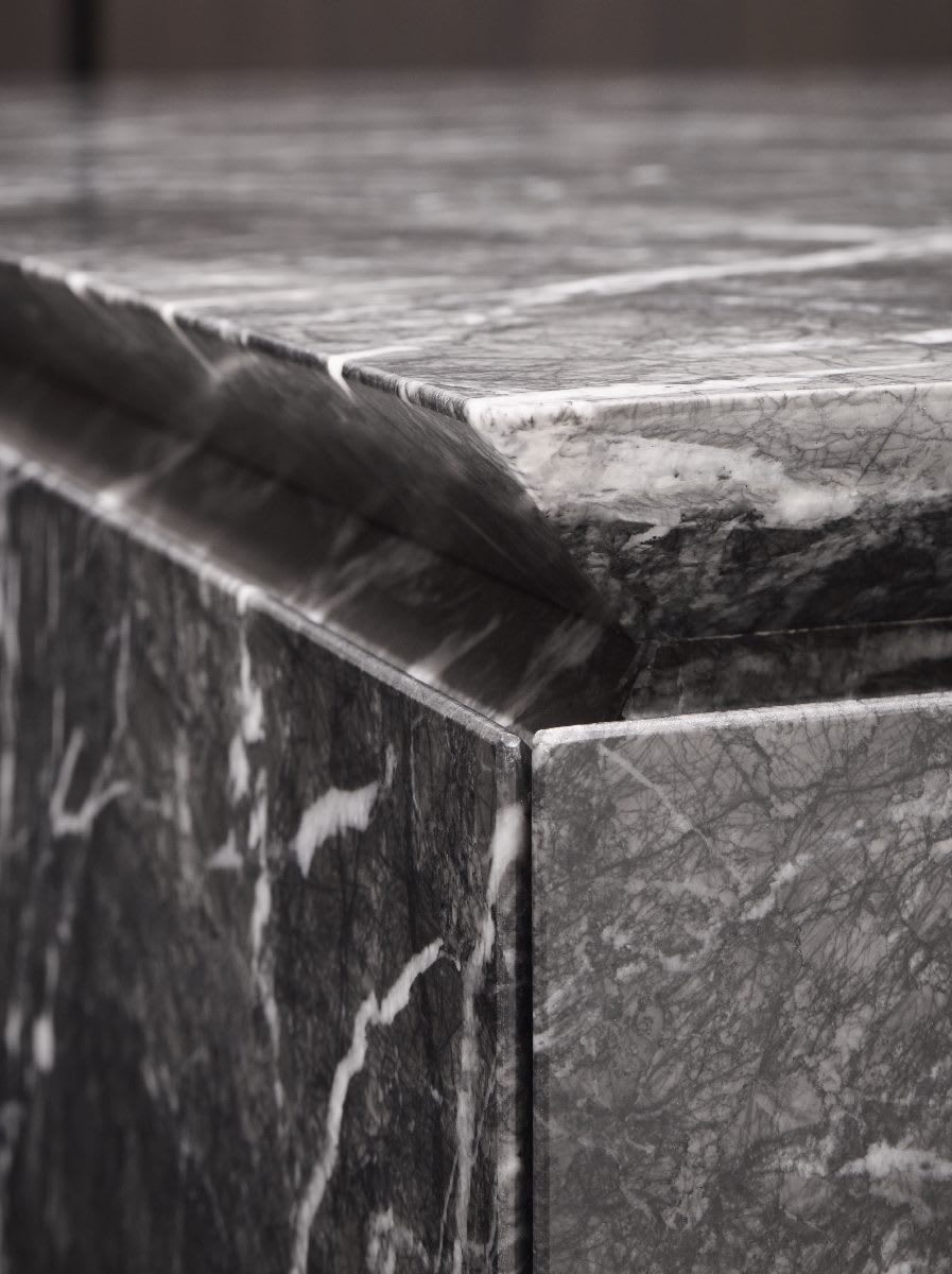 raised counter detail on a kitchen island from eggersmann's unique cabinetry collection finished in black and white stone