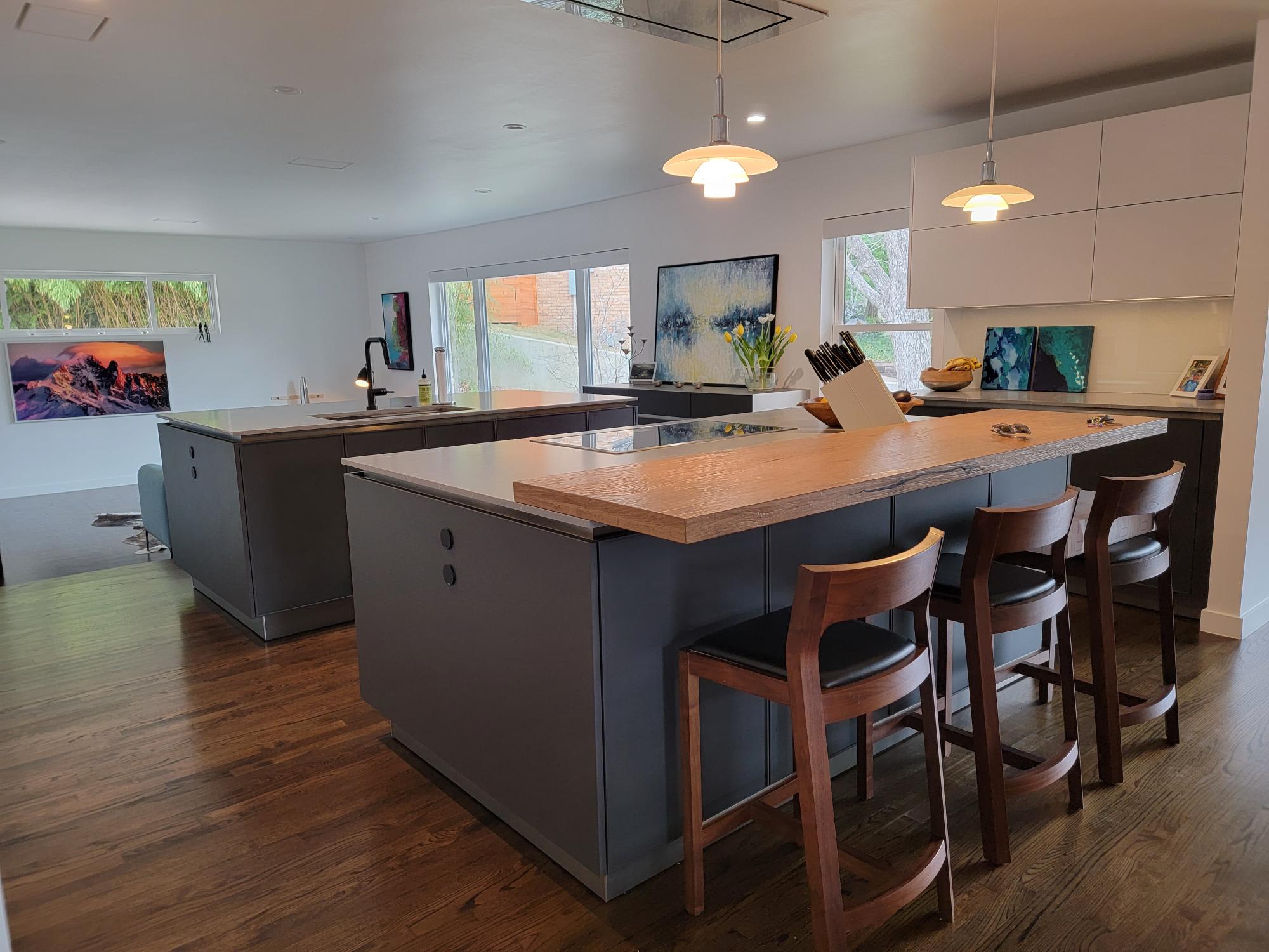 breakfast bar on one of two islands designed by eggersmann for a mid-century home's kitchen dallas' oak cliff neighborhood