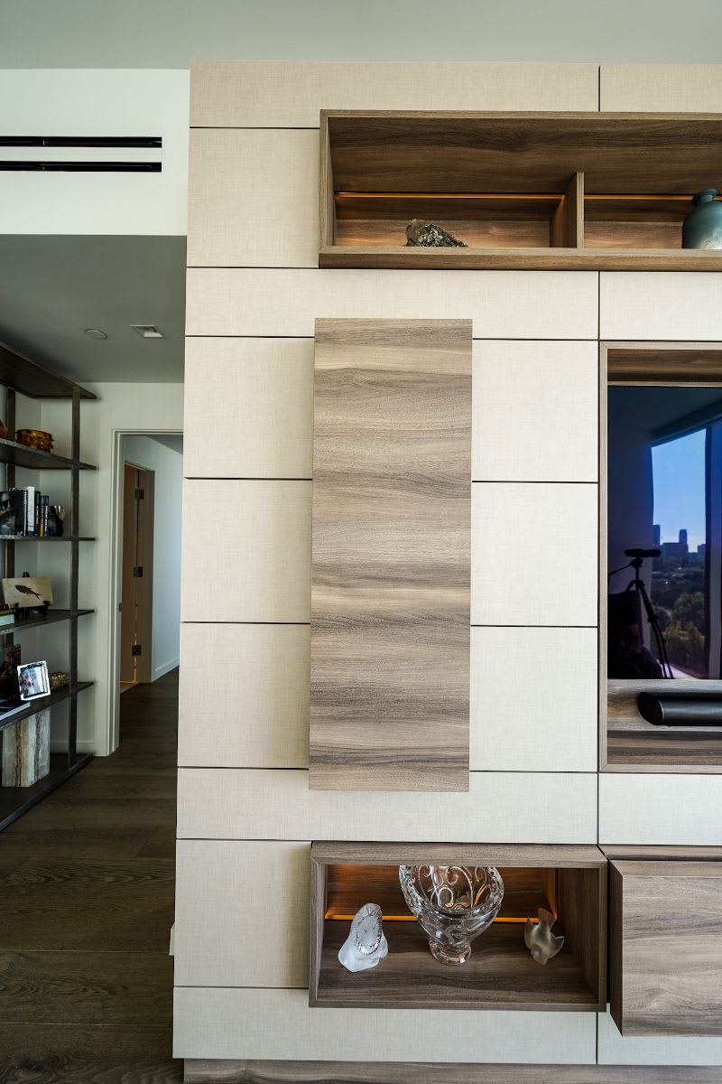 closed door of a storage niche in a modern media wall with a light but warm palette designed by eggersmann for a new four seasons residence in los angeles