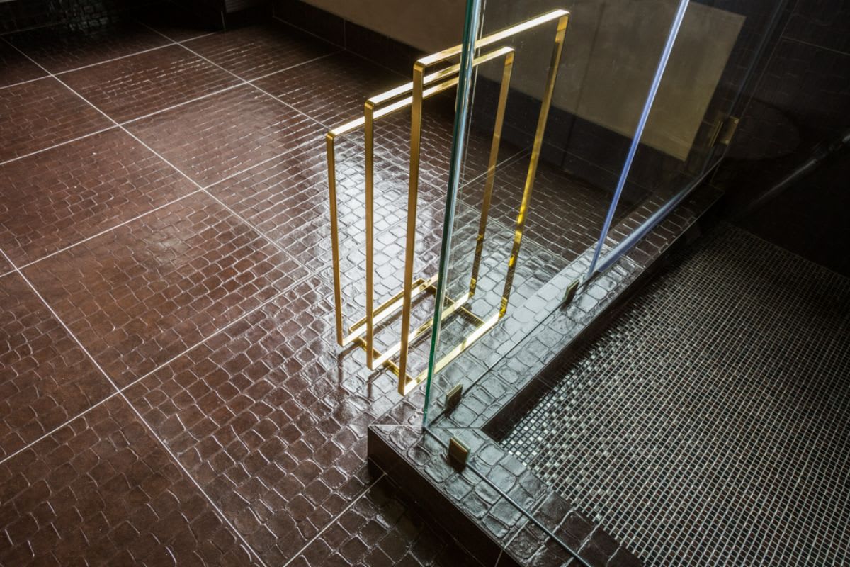 acrylic towel racks and alligator floor tiles in a master bath of a home in the astoria penthouse in houston texas