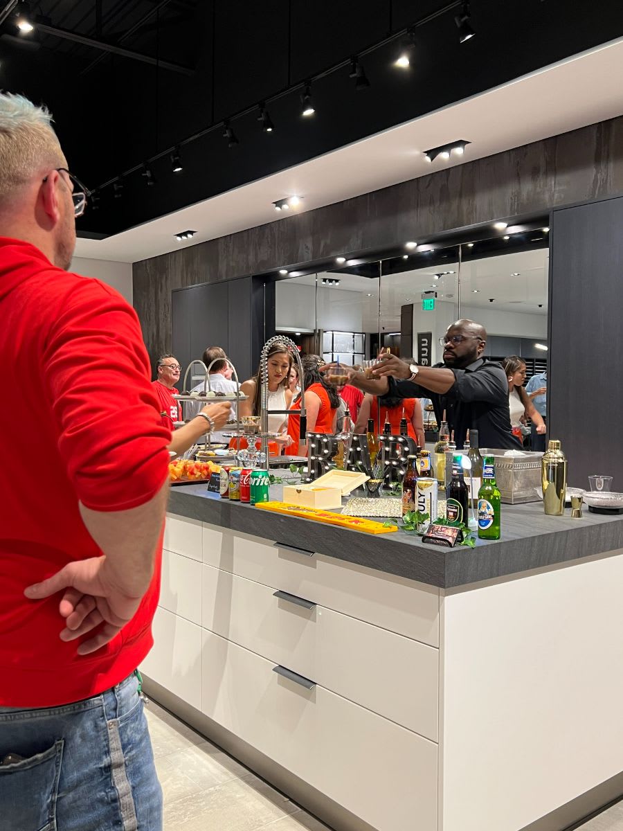 bartender serving drinks at 2022 curated dallas art walk in eggersmann showroom