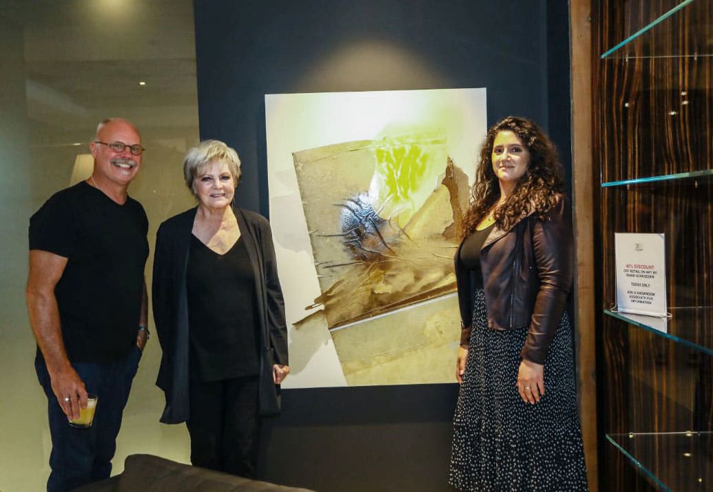 harold skulte adn exhibiting artists pose with a sample of art from the eggesrmann showroom exhibits during the 2-22 RNDD Gallery Walk