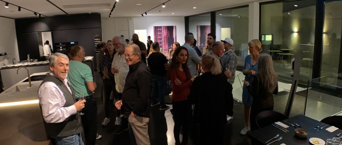 coworkers and clients at a dinner party in the display kitchens at eggersmann factory in hiddenhausen germany