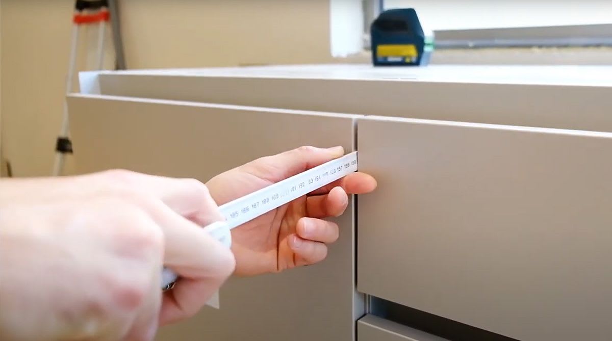 eggersmann installer checking precision accuracy of cabinet door alignment on a luxury home renovation job site